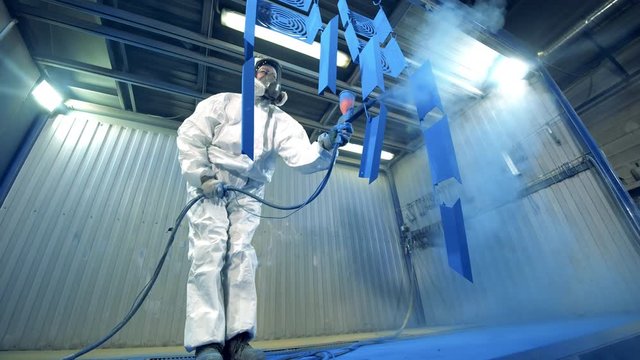 Factory facility with a female expert dying metal parts blue