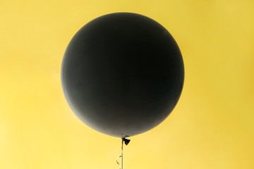 Black baloon on yellow