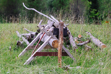 Pile of firewood prepared for the winter and handmade construction for the chopping wood