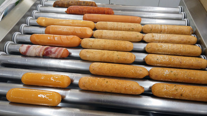 All kind of sausages in sausage rolling grill.