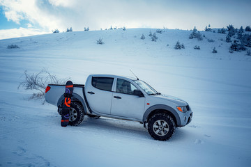 Pickup truck on road, Beautiful winter road under snow mountains. © Seleznov_Molchanova