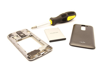 Disassembled smartphone with a battery and a gold cover on a white background