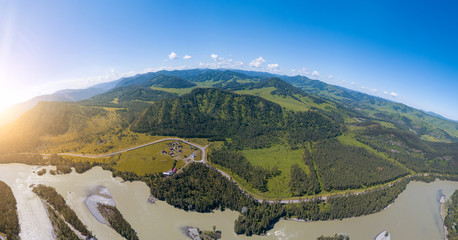 Aerial view of planet earth with nature and picturesque landscape near a mountain along river and green trees on a summer day and blue sky. A small and defenseless planet. Travel and recreation.