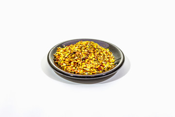 Hot seasoning in plate isolated on white background. Mix of different spices and sea salt. Traditional ingredient for cooking Italian food
