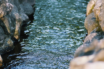 Flowing water behind the wet rocks