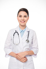 Fototapeta premium Attractive doctor in white coat and stethoscope smiling at camera isolated on white