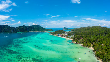 Fototapeta na wymiar Panorama of tropical islands Phi Phi Don and Phi Phi Leh in sea. Vacation holidays concept background. Aerial view of Tonsai bay with many boats and speedboats above coral reef. Krabi, Thailand