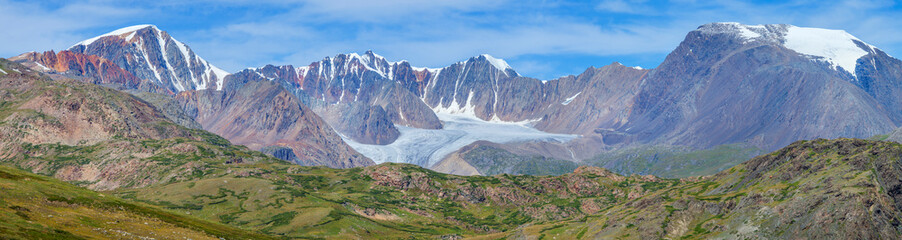 Panoramic mountain view. Rocky peaks, glaciers, treeless. Traveling in the mountains, trekking.