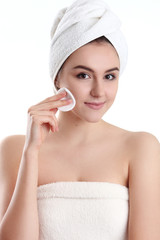 close-up of beautiful young woman with bath towel on head covering her breasts, on white