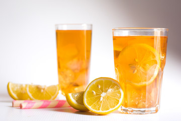 Glasses of ice tea with lemon slices and mint on white background