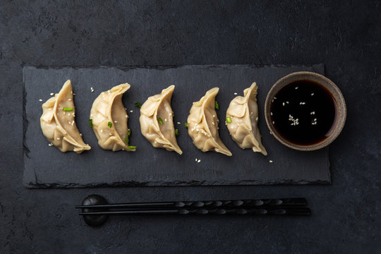 Traditional japaneese gyoza dumplings on black slate plate