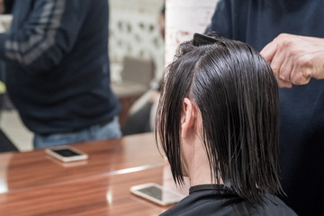 Fototapeta premium Female client getting haircut by hairdresser