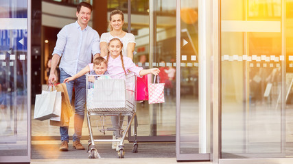 Family with children in shopping cart while shopping