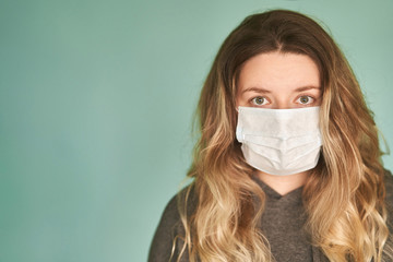 Girl in a medical mask on a green background. Coronavirus. Prevention of viral diseases