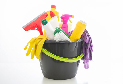 Cleaning supplies in a bucket isolated against white background.