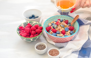 High protein healthy breakfast, buckwheat porridge with blueberries, raspberries, flax seeds and honey Closeup view, selective focus