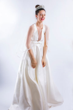 Bride laughing expressively on studio during the photo session.