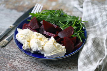 Selective focus. Delicious salad with beets, arugula and mascarpone cheese. Keto salad. Keto diet.