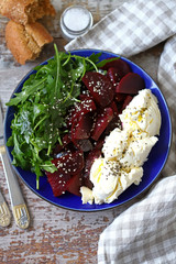 Selective focus. Delicious salad with beets, arugula and mascarpone cheese. Keto salad. Keto diet.