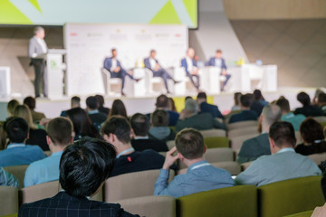 Business conference attendees sit and listen