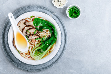 Asian Vegetarian Udon or Ramen noodles soup in bowl with Shiitake mushrooms and Bok Choy