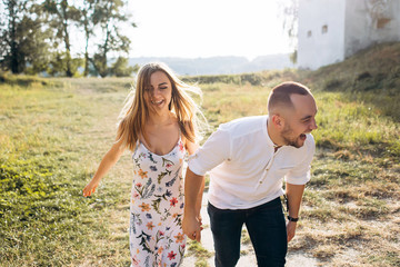 Fototapeta premium Candid photo of extremely happy young couple enjoy life together with natural outdoor laisure activity lifestyle outside during the summer and the sunset in backlight