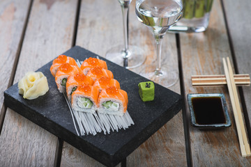 Traditional rolls with fish and rice on a white plate with sauce and wasabi. Japanese food.