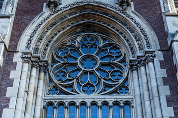 An ancient iron window with decorative elements on the facade of a church