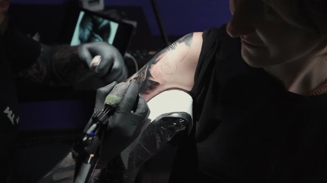 Video of man doing tattoo for woman in studio