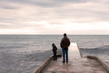 Father and son walking by the sea.
