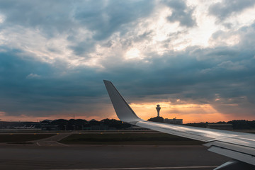Fototapeta na wymiar The plane is going to runway during sunset