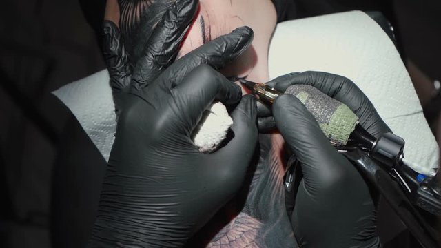 Video of man doing black tattoo of snake