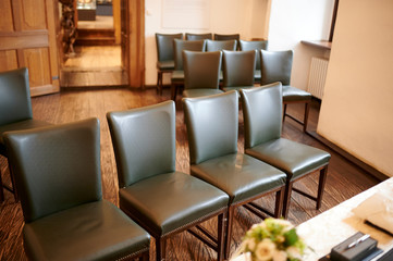 Leere Stühle auf einem Standesamt warten auf die Brautleute