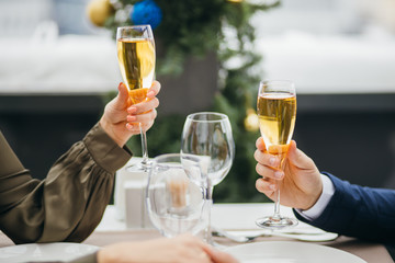 close-up of glasses filled with champagne, man and womanstaurant clinking glasses, going to drink. isolated in restaurant