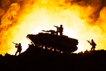 Battle scene of toy tank and soldiers with fire at background
