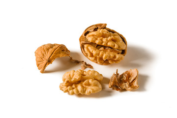 Still life with whole and shelled walnuts on a white background.
