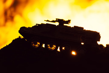 Battle scene with toy tank and fire at background