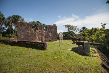 Old brick fortress walls of Fort Zeelandia in the subtropics against a background of green trees...