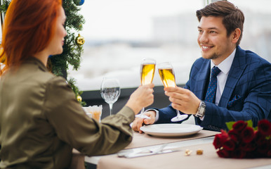 happy caucasian couple celebrating birthday or st valentines day, 14 february in rich restaurant. redhaired female in dress and handsome man in elegant tuxedo spend time together, have dinner
