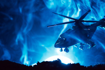 Battle scene with toy helicopter in smoke with moon on blue background