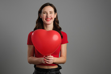 Beautyful emotional brunette girl with red balloon