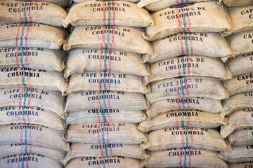 Fototapeten Stack of burlap sacks Colombia coffee, backdrop, template. © zakokor