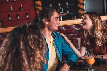 Group of friends enjoying in cafe together, talking and drinking coffee.