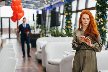 Fototapeta premium saint valentines day, celebration, holidays concept. young caucasian man and woman on a date in restaurant. attractive lady waiting for a man