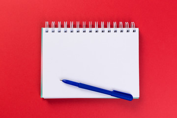 top view of blank open notebook on red background, office equipment, school supplies and education concept