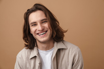 Image of joyful young man laughing and looking at camera