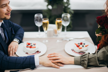 lovely caucasian couple spend time in luxury restaurant, male in tux and woman in dress sit at table, enjoy spending time together. gentleman and lady in love.