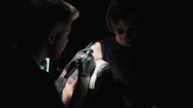 Shooting of doing tattoo of snake for woman in studio
