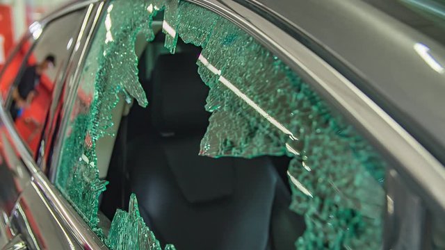 A front window of the car has been damaged. The vehicle is in a repair shop.