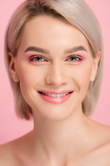 cheerful attractive girl with pink makeup, isolated on pink